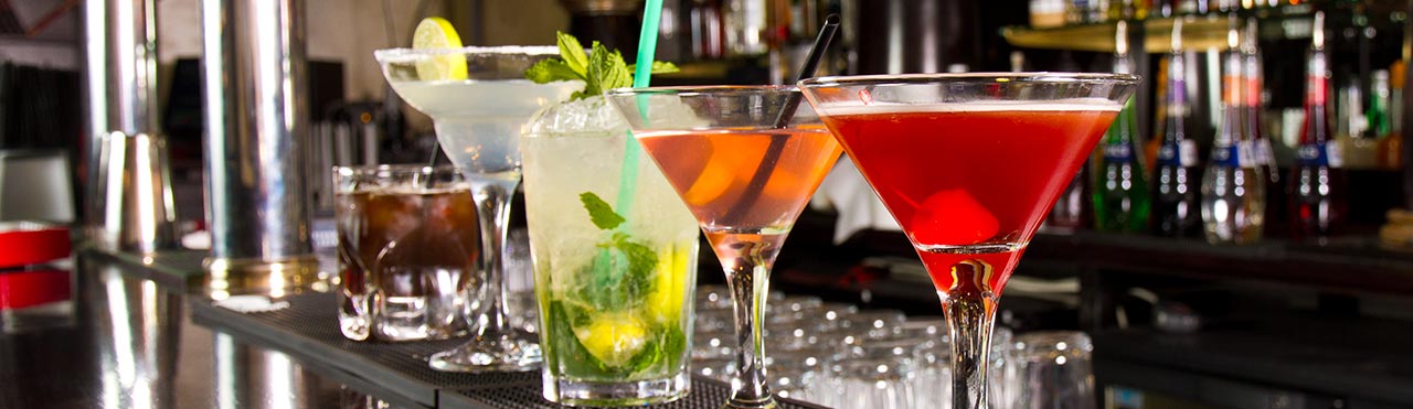 Cocktails are ready to be served on a clean bar in a café.